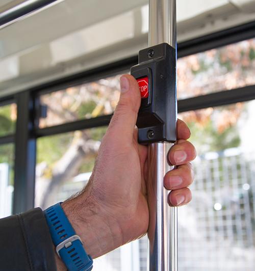 Botón de parada de autobús con una mano pulsando